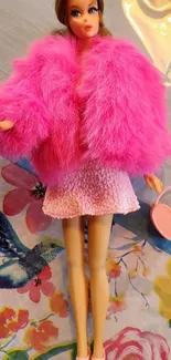 Fashion doll in pink fluffy coat with floral background.