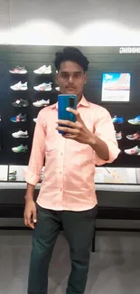 Mirror selfie in fashion store, light pink shirt.