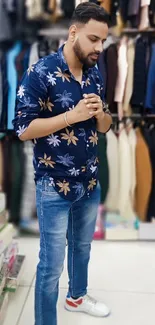 Man in floral shirt and jeans in clothing store.