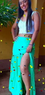 Woman in green skirt and white top with a warm background.