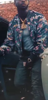 Fashionable man in floral jacket leaning against car door.