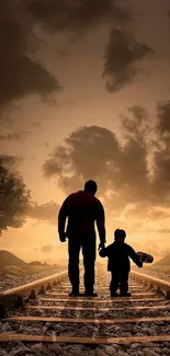 Father and child silhouette on railway tracks at sunset.