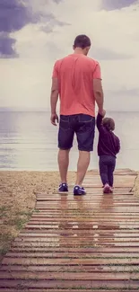 Father and child walking along a serene beach path toward the ocean.