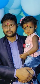 Father holding child in celebration, colorful decor.