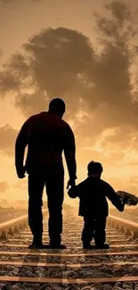 Silhouette of father and child at sunset on railroad tracks.