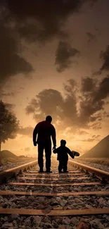 Silhouette of a father and child walking on railway tracks at sunset.