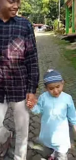 Father and child walking on a sunny street.