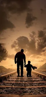 Father and child walking on railroad at sunset.