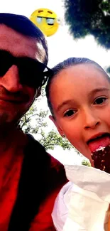 Father and daughter enjoying ice cream outdoors.