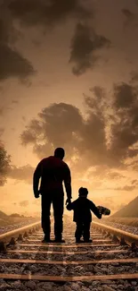 Father and son silhouette on train tracks at sunset.