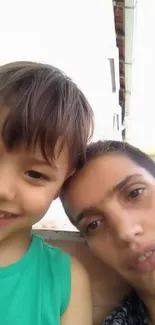 A father lovingly embraces his smiling son.