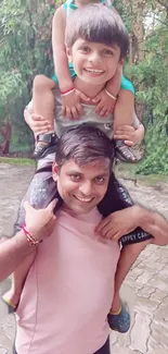 Father carrying son on shoulders in green park.