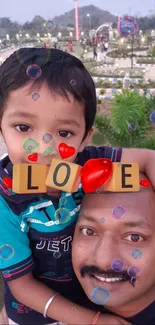 Father and son in park with LOVE blocks and bubbles.