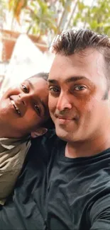 Father and son smiling in an outdoor selfie.