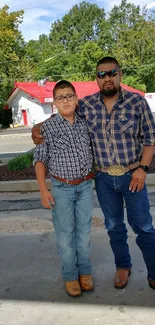 Father and son in plaid shirts outdoors.