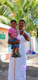 Father holding son outdoors with lush greenery.