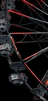 Illuminated Ferris wheel glowing red against a dark night sky.