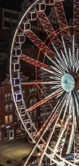 Night view of a Ferris wheel in urban landscape.