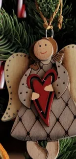 Wooden angel ornament with heart on Christmas tree.