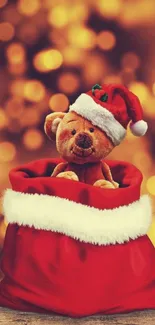 Teddy bear in Santa hat inside red sack, golden bokeh background.