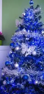 Blue Christmas tree with festive decorations.