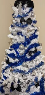 Blue and white Christmas tree with silver baubles and black hat.