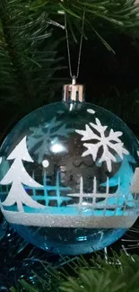 Festive blue Christmas ornament with snowflake and tree patterns on a green tree.