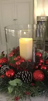 Festive holiday centerpiece with candle, red accents, and pine wreath.