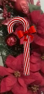 Festive candy cane with poinsettias on holiday wreath.