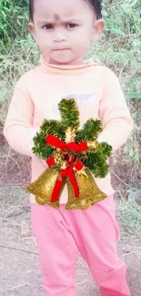 Child holding decorative bells in a festive setting.