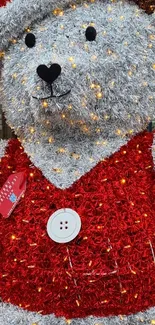 Festive teddy bear with red tinsel and holiday lights.