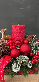 Christmas centerpiece with red candle and ornaments on wood.