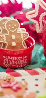 Festive Christmas cookies in a red bowl with holiday decorations.