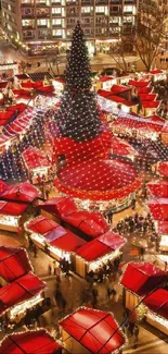 Festive Christmas market with red stalls and a central Christmas tree.