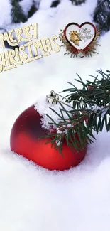 Red ornament in snow with Merry Christmas text and pine branches.