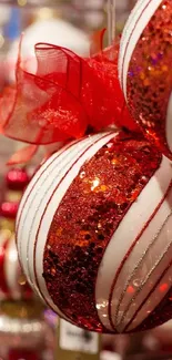 Red and white Christmas ornaments with lights in the background.