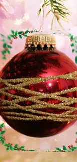 Red Christmas ornament with gold glitter on festive background.