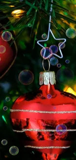 Red Christmas ornament on tree with bubbles and festive lights.