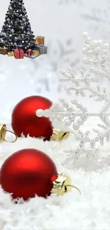 Festive Christmas wallpaper with red ornaments on snow.