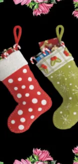 Christmas stockings with pink floral border on black background.