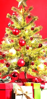 Christmas tree with red ornaments and gift boxes on a red background.