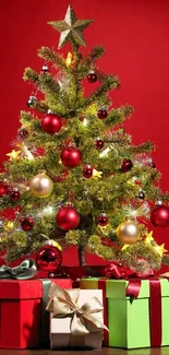 Festive Christmas tree with ornaments and gifts on a red background.