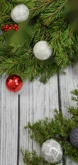 Festive Christmas wallpaper with ornaments and green branches.