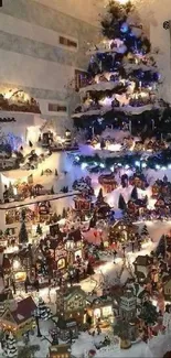 Illuminated Christmas village beneath decorated tree.