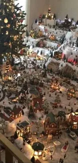 Christmas village display with tree and miniatures.