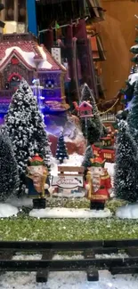 Festive Christmas village scene with snow-covered cottages and trees.