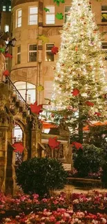 Illuminated Christmas tree in city square with flowers and historic buildings.