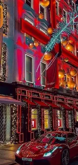 Festively decorated street with red sports car at night.