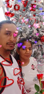 Couple in front of Christmas tree with love decorations and red accents.