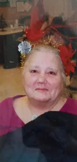 Elderly woman with festive red decorations in a vibrant portrait.